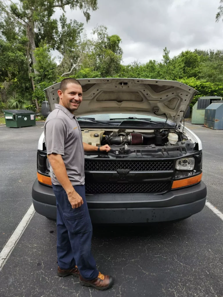 Dimas staning with his van